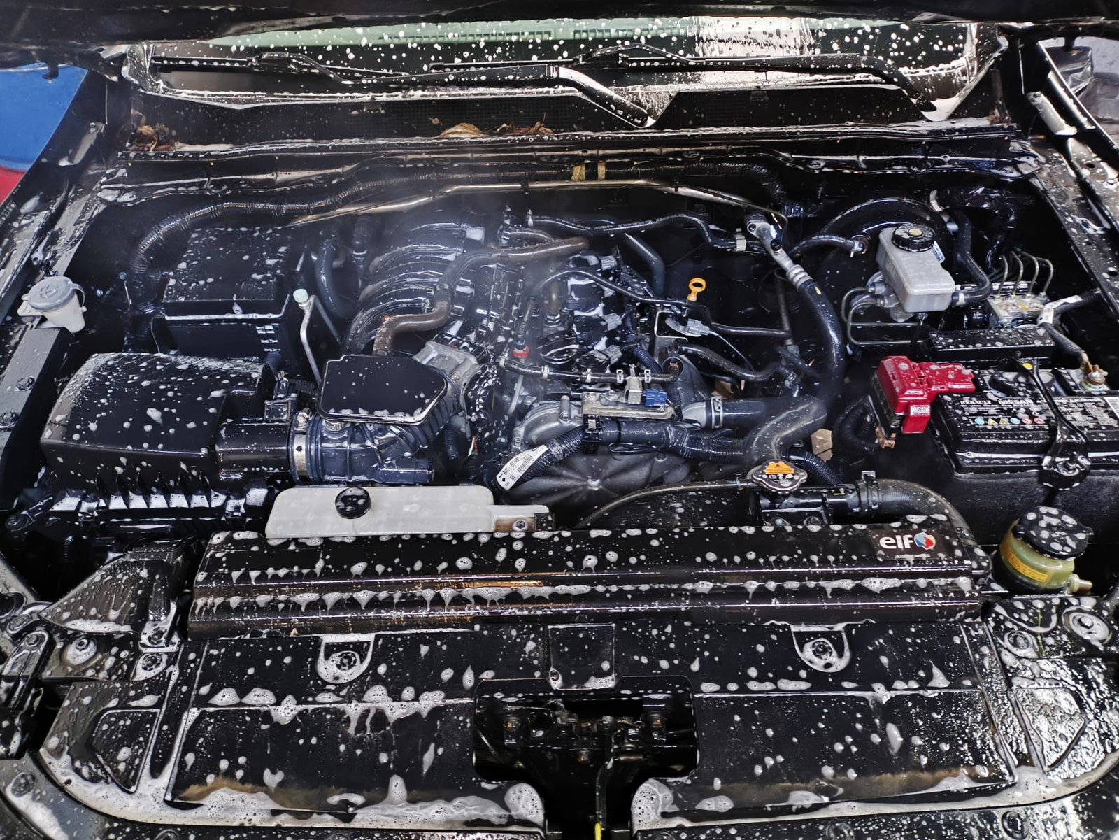 Motor cubierto de espuma durante el lavado a detalle